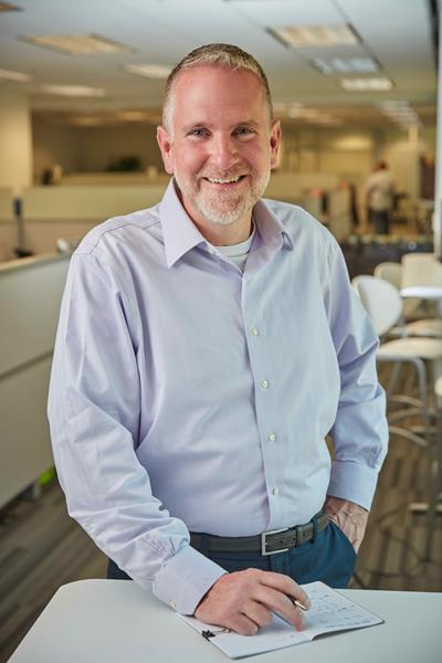 Ed Rusch standing in a modern office while serving at Command Alkon