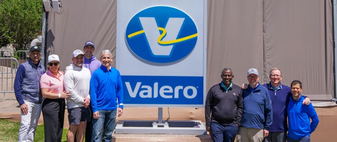 Grace leadership colleagues gathered beside a Valero sign at the 2025 Valero Texas Open