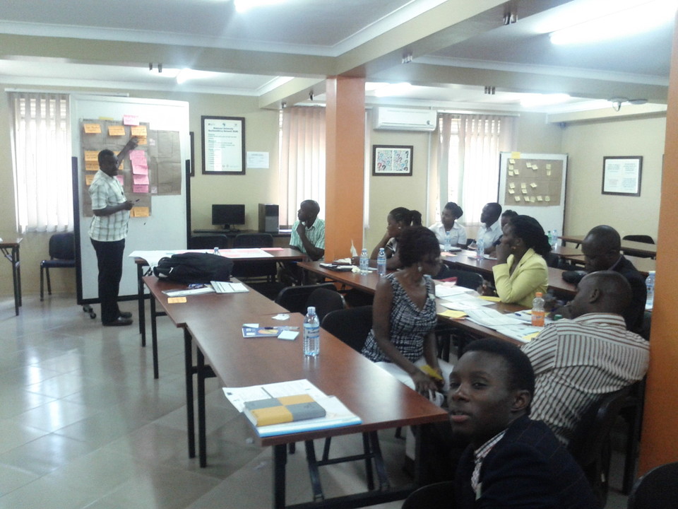 Participants at a Finding XY-facilitated business training in Uganda, with workshop notes on the walls