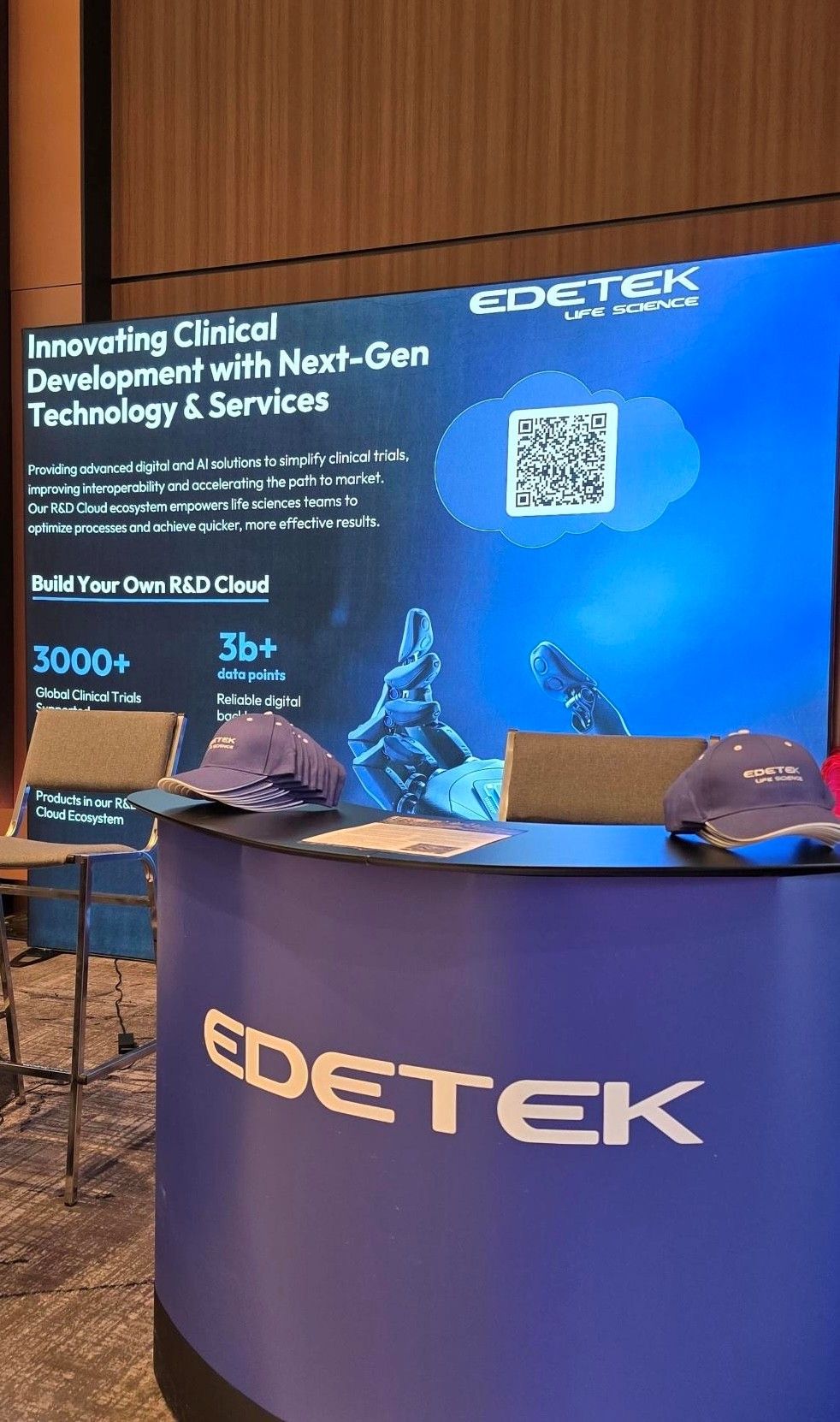 EDETEK’s blue exhibition booth at Bio-IT World 2025, with clinical development messaging and branded caps