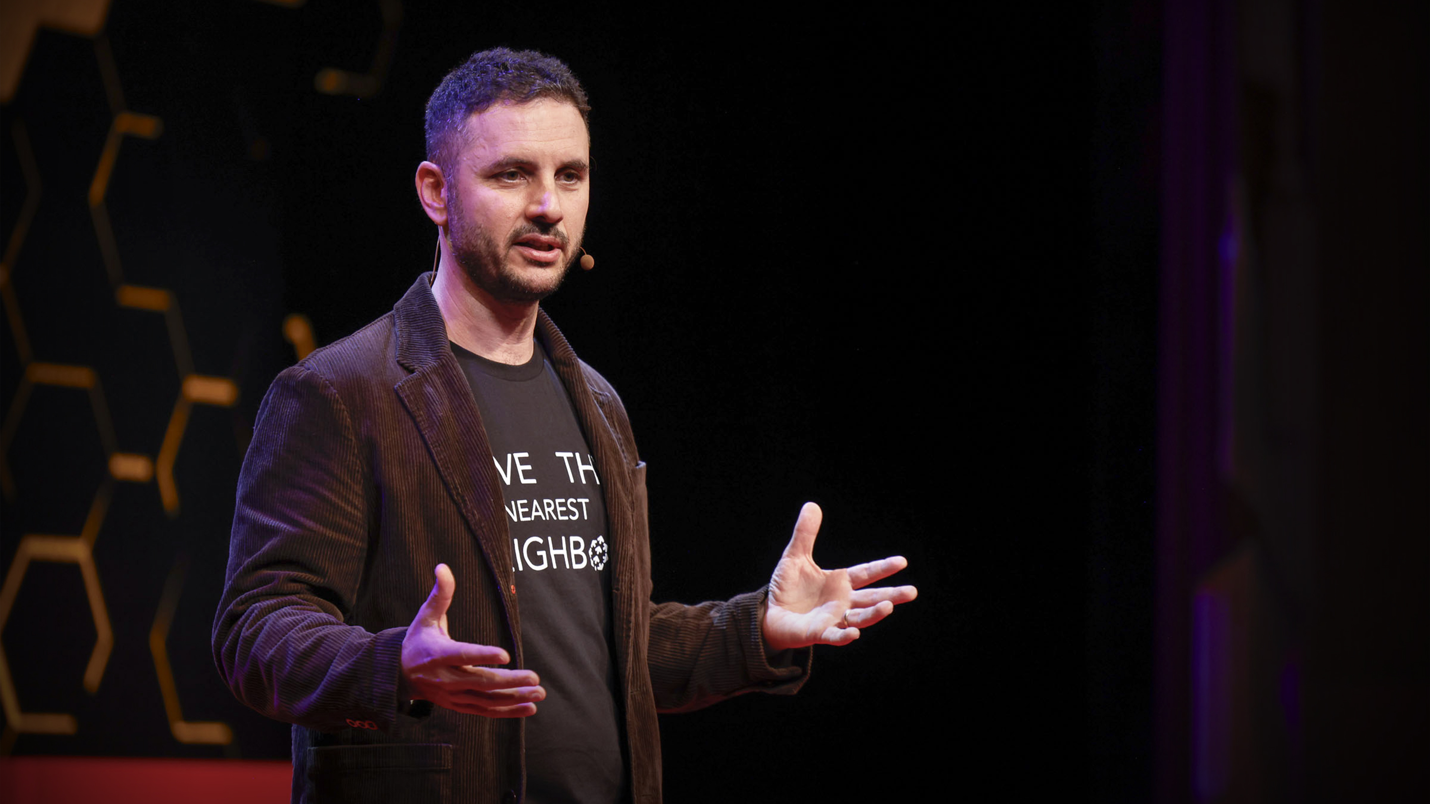 Edo Liberty speaking on the TEDAI stage in 2023, gesturing with both hands.