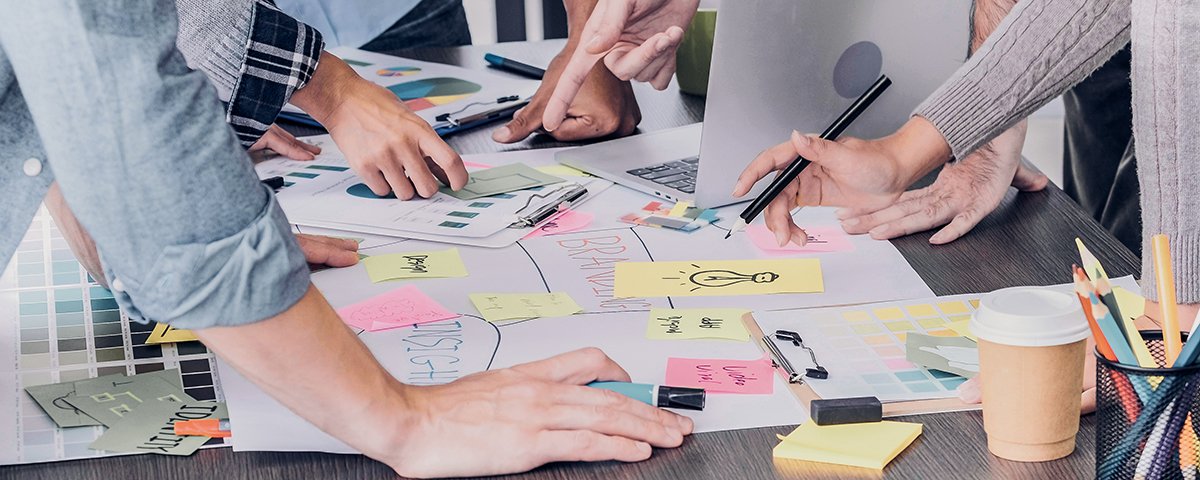 A strategic planning table with printed charts, notebooks and working materials