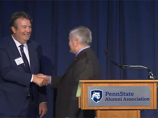 Edward Dowling shakes hands with Penn State President Eric Barron at the Alumni Fellow presentation.