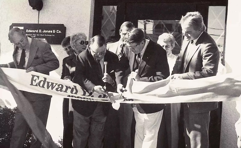 An archival black-and-white photograph of a ribbon cutting for Edward Jones's thousandth branch