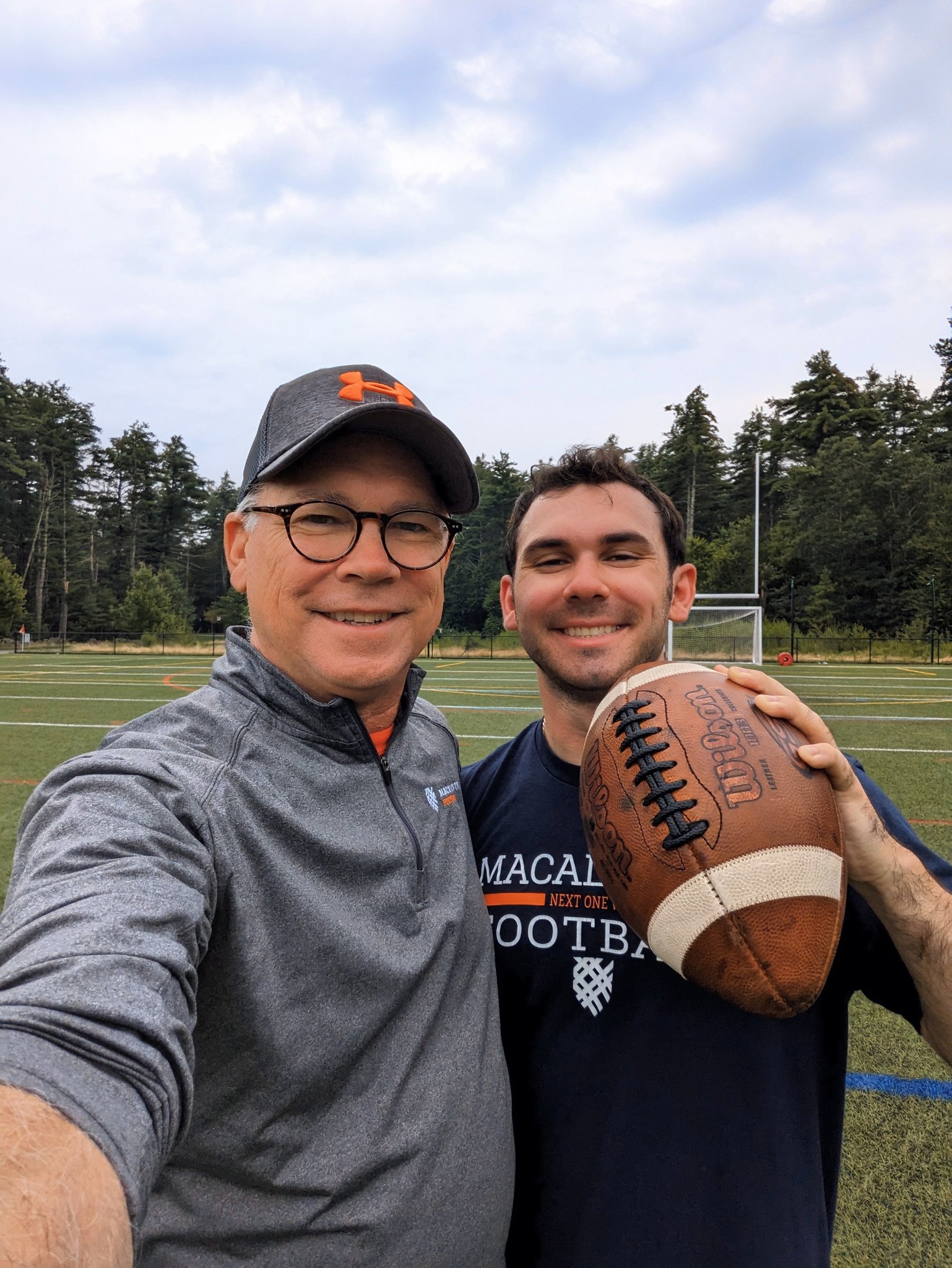 Edward Lastes and his son Marshall on a football field, holding a football