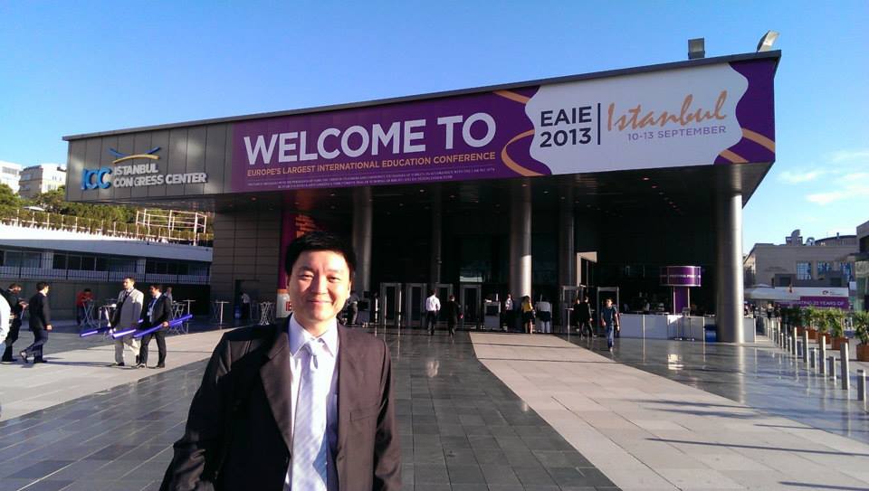 Edwin Tay outside the Istanbul Congress Center beneath the EAIE 2013 conference banner