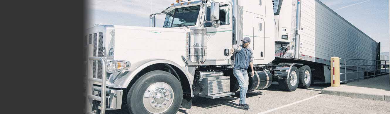 A driver beside a tractor-trailer in an EFS website marketing photograph