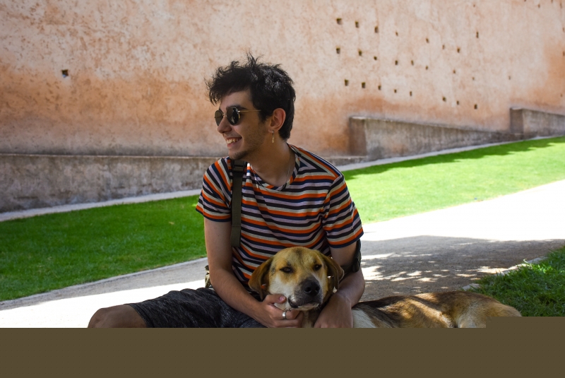 Ege Duman sitting outside with a dog