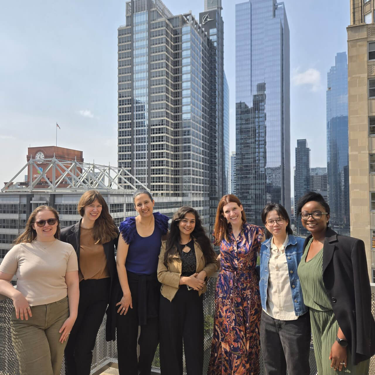 Seven Egen team members standing on a rooftop with Chicago buildings behind them