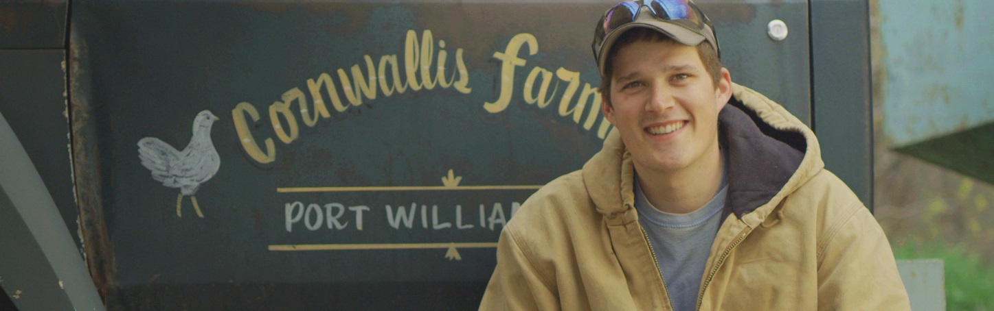 A Canadian egg farmer seated beside a farm truck at Cornwallis Farms in Port Williams