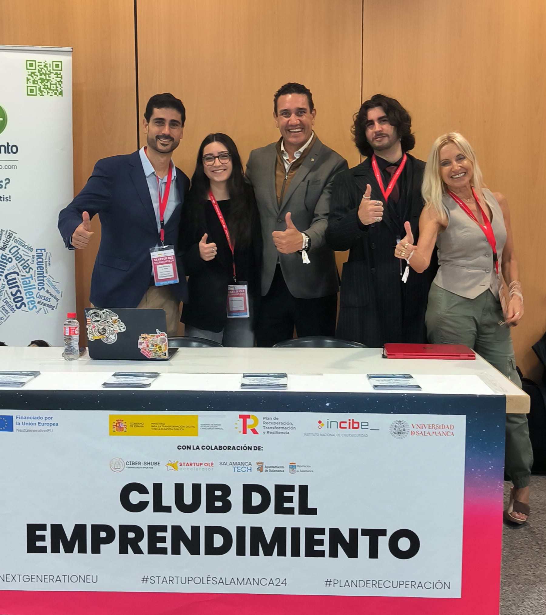 Five participants beside the Club del Emprendimiento display at Startup OLÉ Salamanca 2024