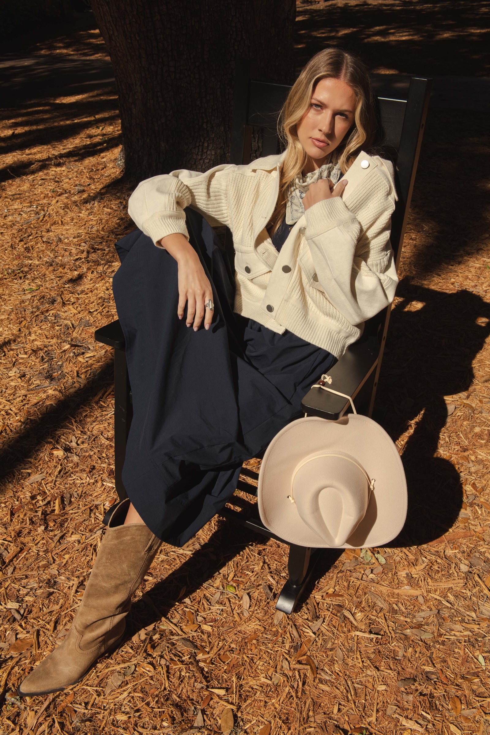 ELAN campaign showing a cream knit jacket paired with dark trousers outdoors