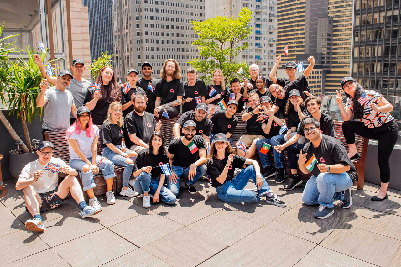 Appwrite team members gathered outdoors in New York holding small national flags