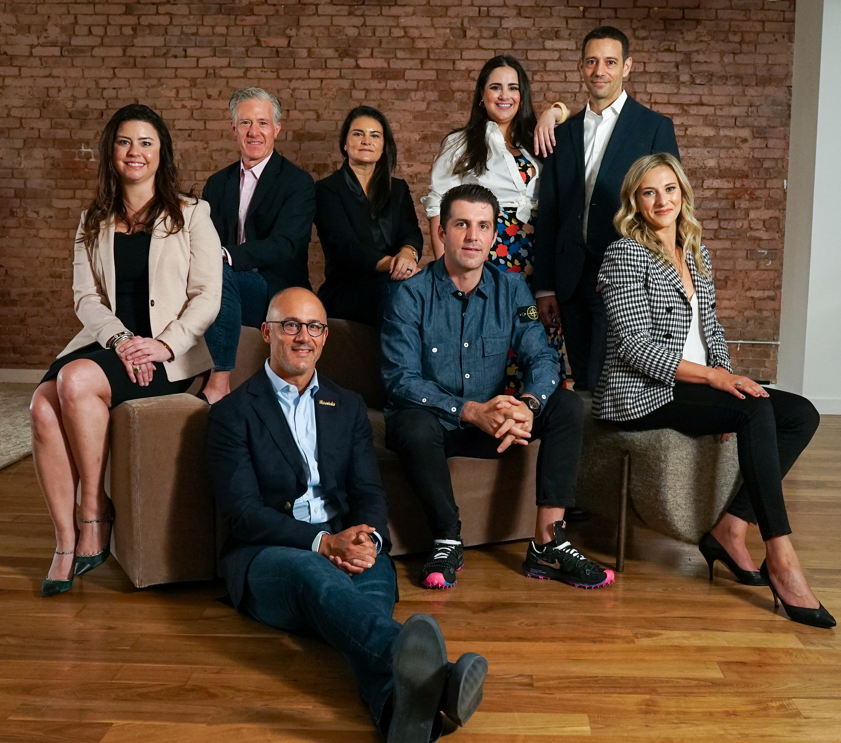 Electric executives posed together in a brick-walled office in a 2022 press photograph