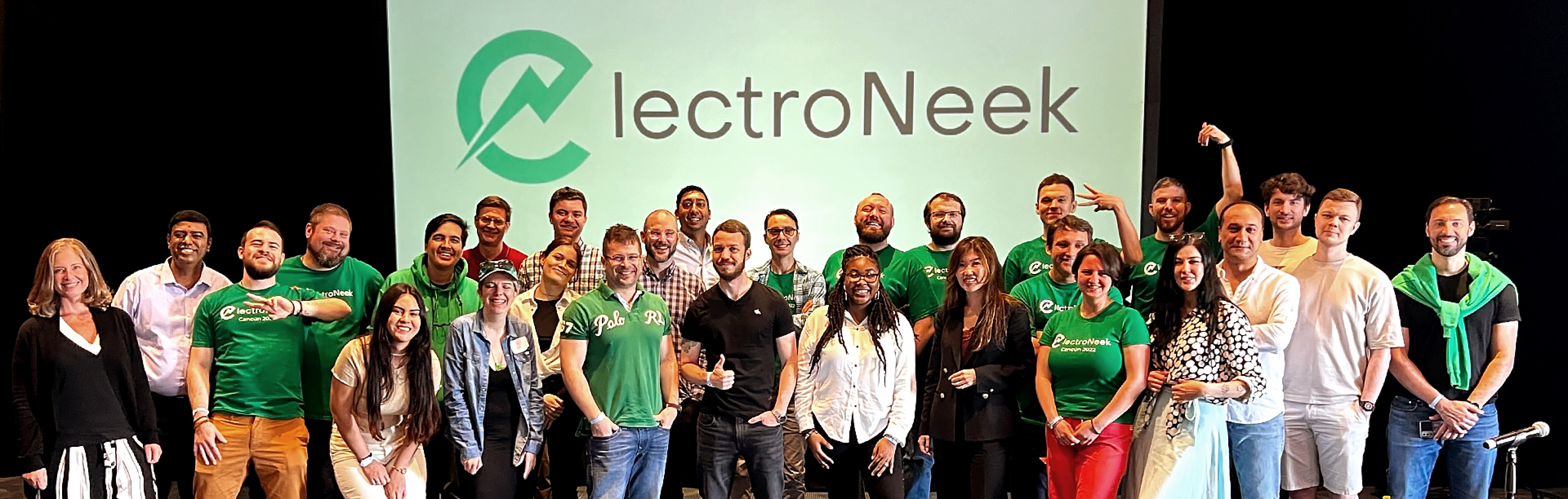 ElectroNeek group gathered on a stage beneath the company name