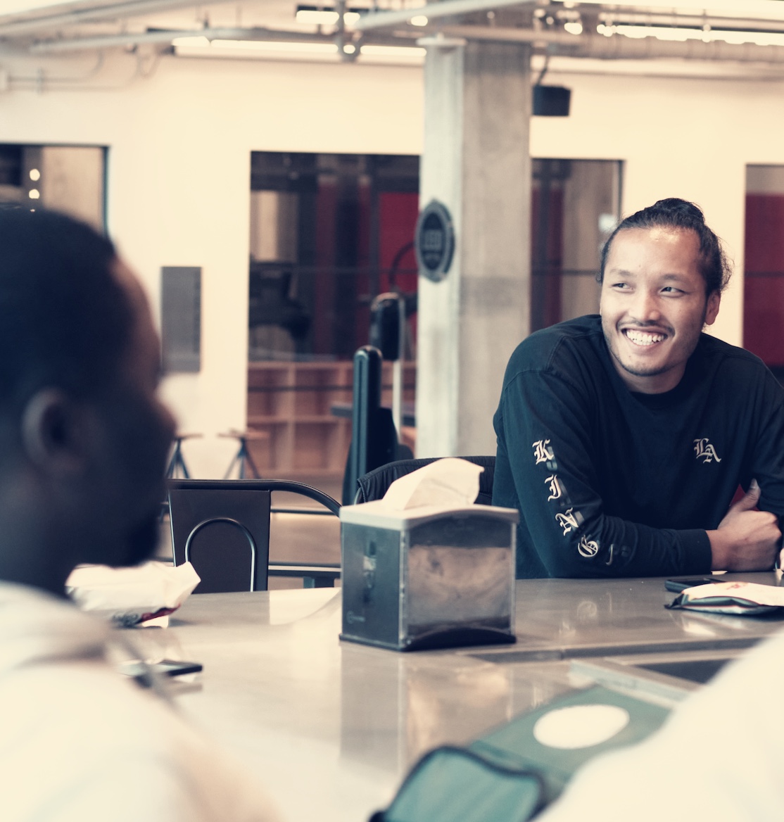Colleagues talking around a table in ElevateBio’s office