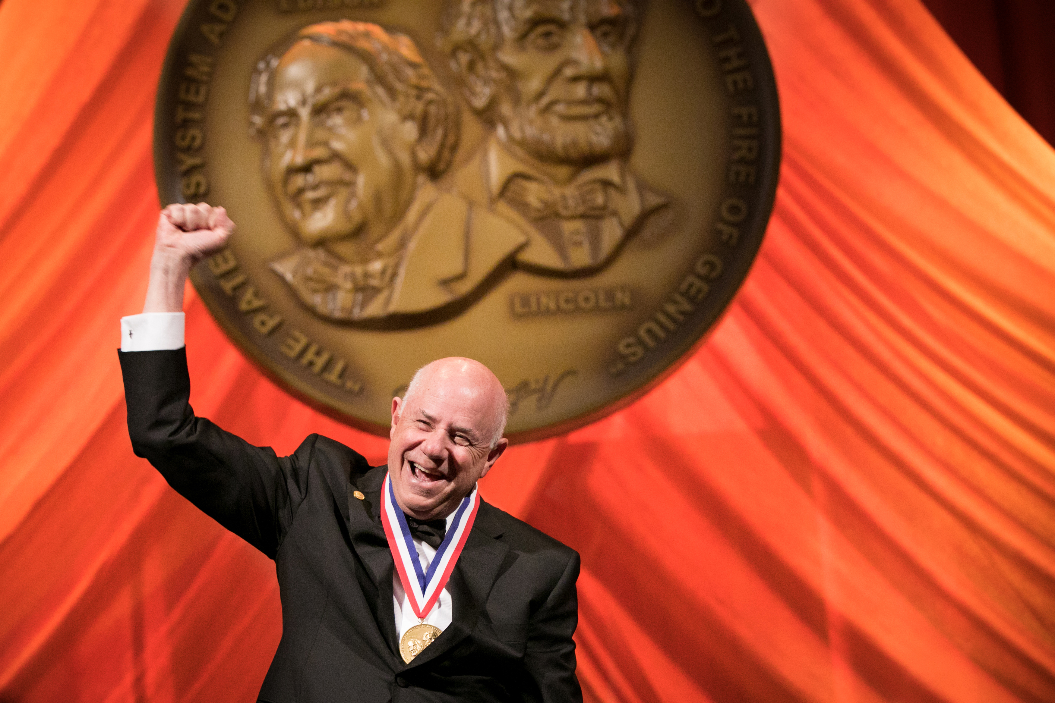 Eli Harari speaking while wearing his National Inventors Hall of Fame medal