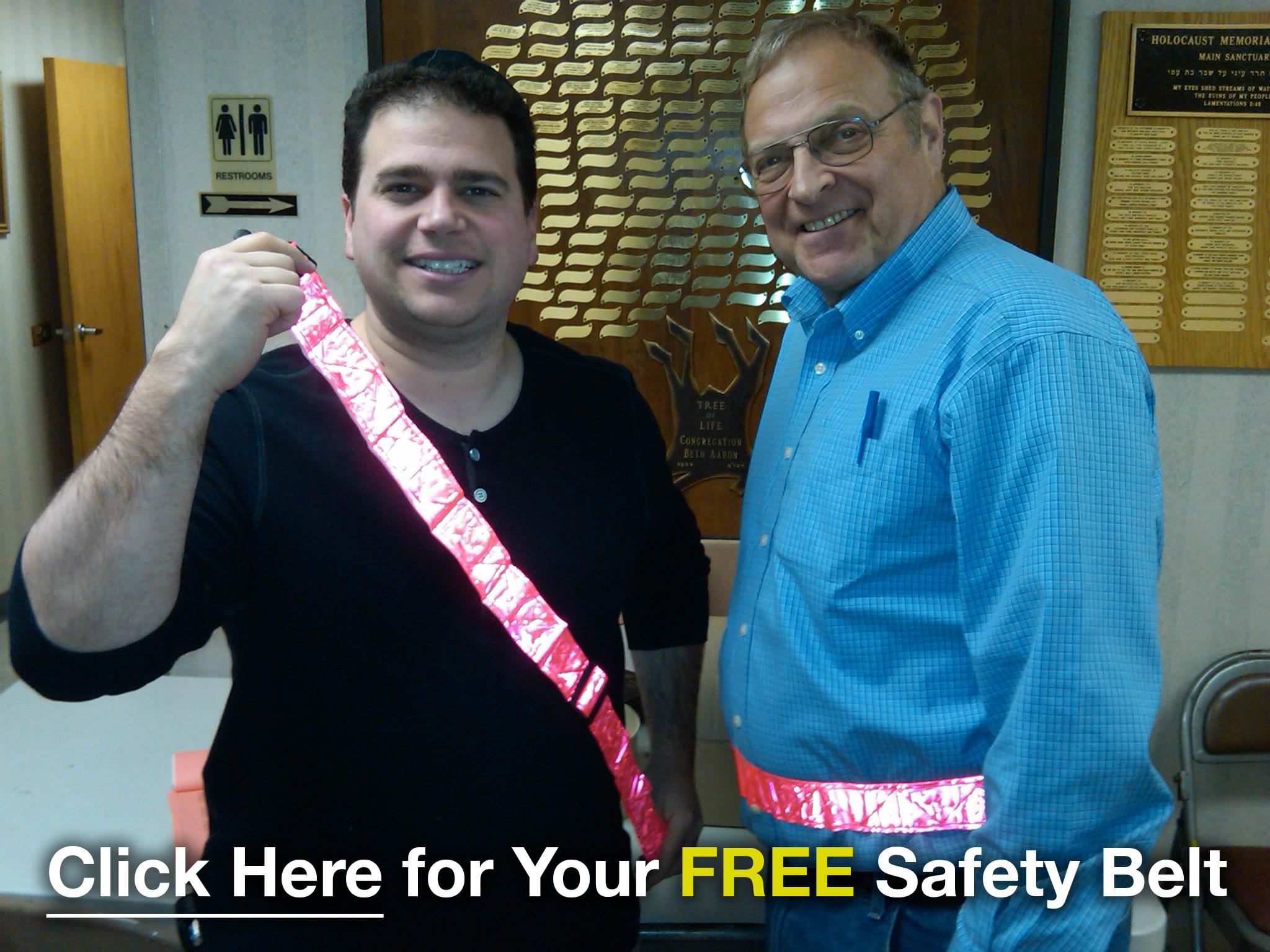Elie Y. Katz, left, and another man display bright reflective safety belts in a community photograph.
