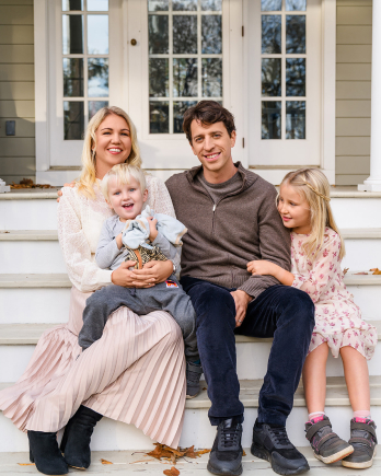 Elina and Raoul Scherwitzl sitting with their two children on outdoor steps