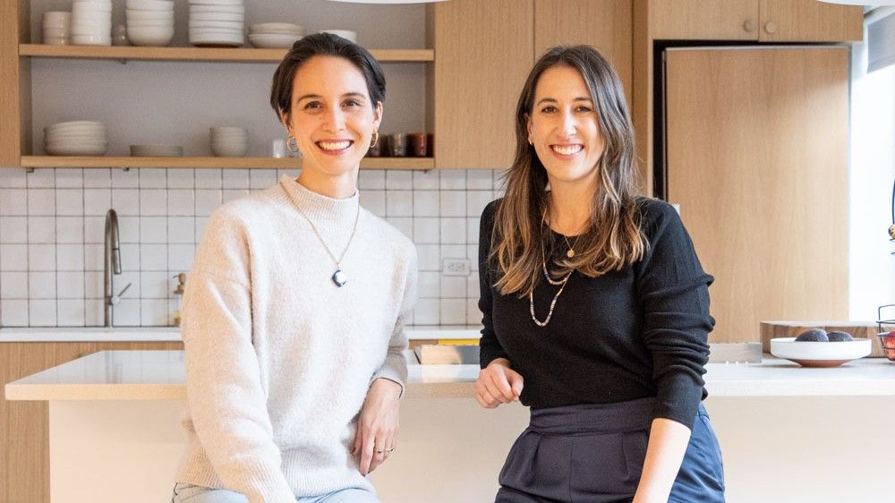 Nicole Centeno and Elise Densborn standing together in a bright kitchen