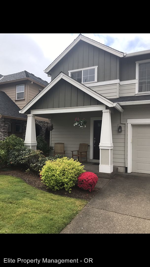 Covered porch and landscaped front garden in a historical Corvallis rental photograph bearing Elite’s name
