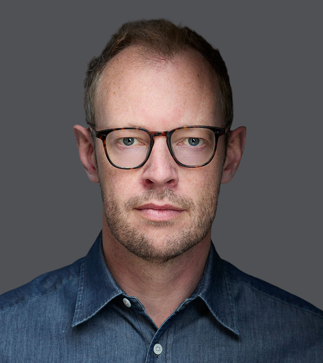 Elliptic co-founder James Smith wearing glasses and a denim shirt