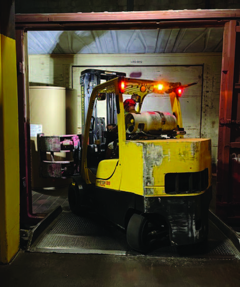 An ELM forklift moving paper rolls directly from a railcar into the warehouse