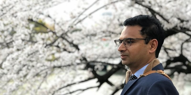 Eltropy co-founder Ashish Garg standing outdoors beneath flowering trees