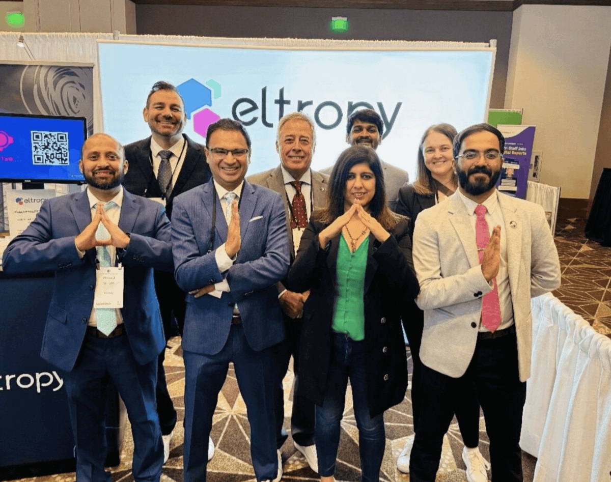 Eight Eltropy team members gathered at the company's exhibition booth