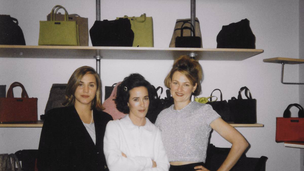 Pamela Bell, Kate Spade and Elyce Arons standing in front of shelves of handbags