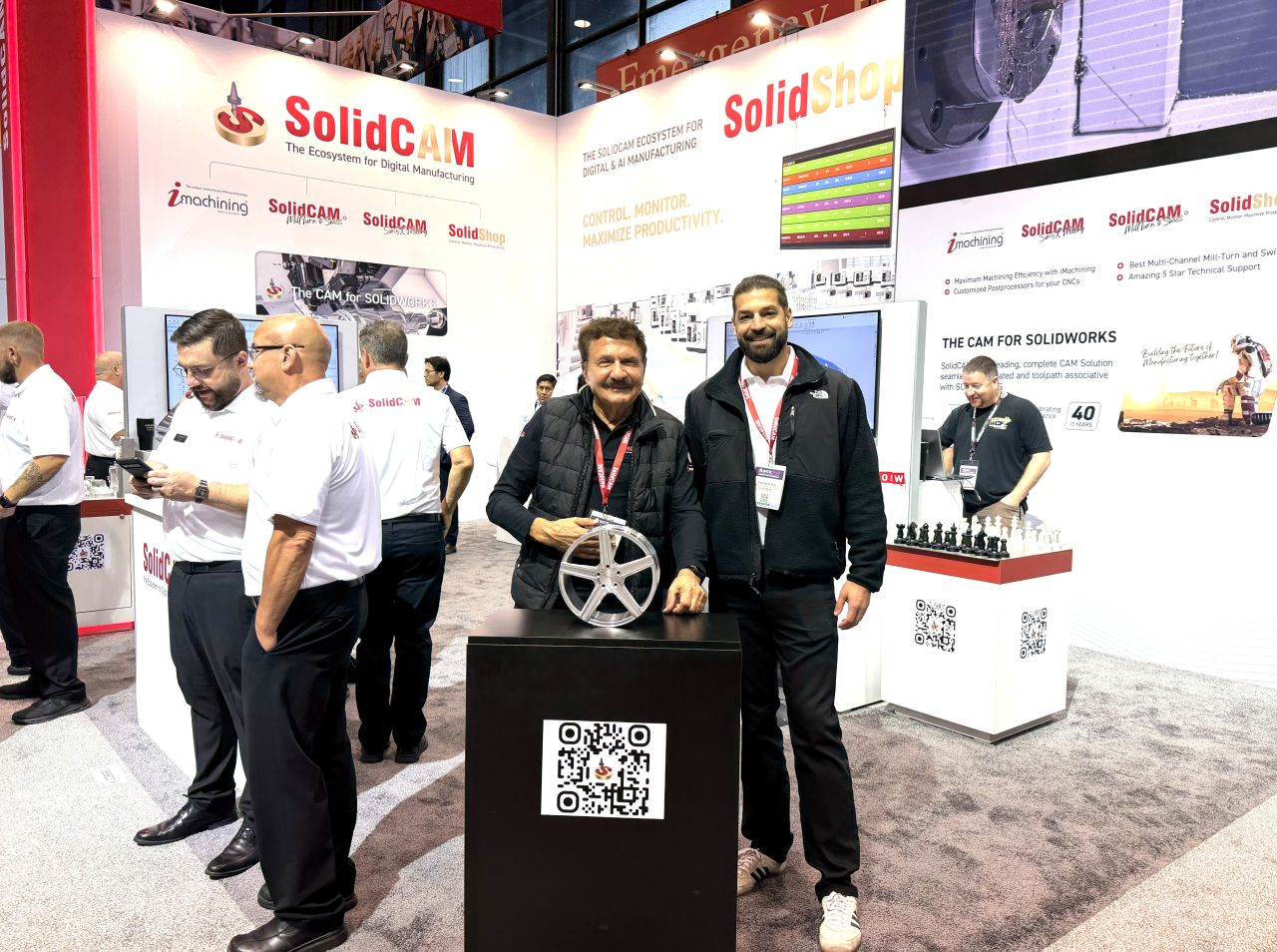 Emil Somekh with a visitor and a machined wheel at the SolidCAM booth during IMTS 2026