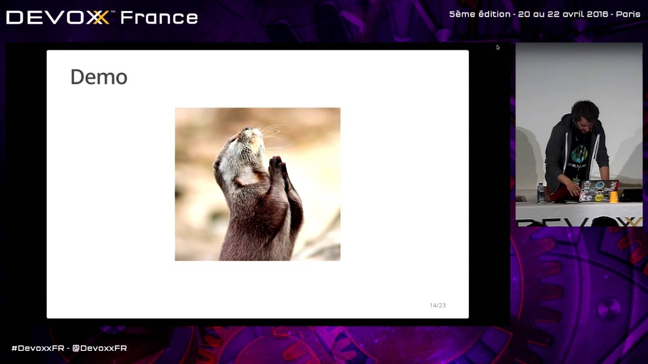 Emile Vauge at his laptop during Devoxx France 2016, beside a demo slide featuring a praying otter