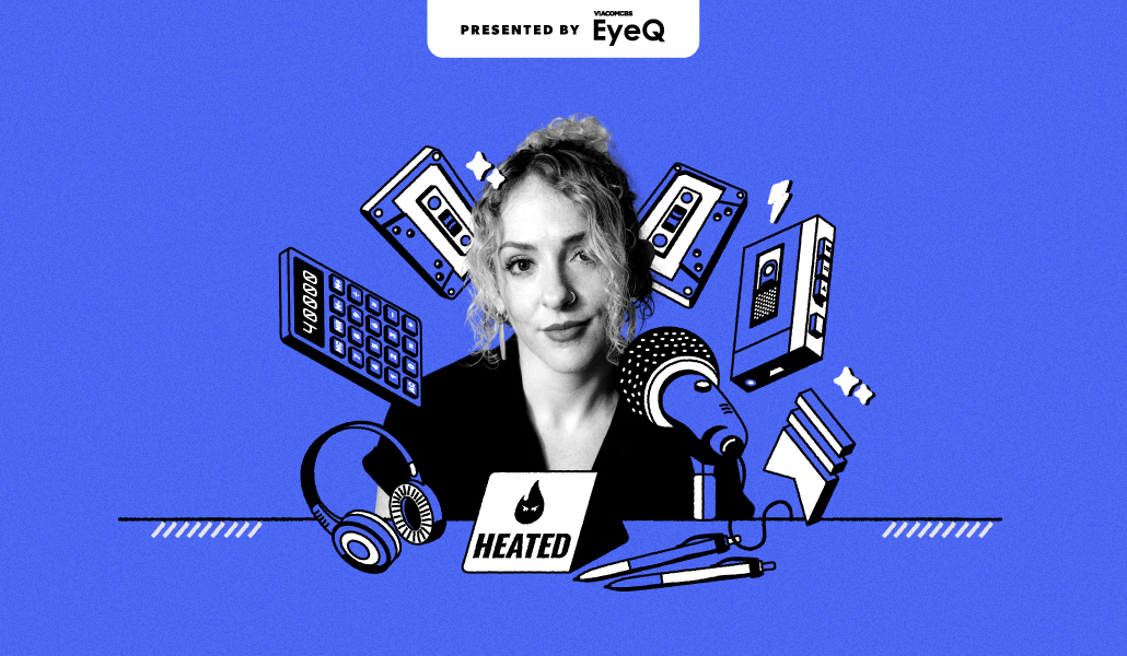 An editorial portrait of Emily Atkin at a laptop surrounded by a microphone, headphones, notebooks, and cassette tapes on a blue background