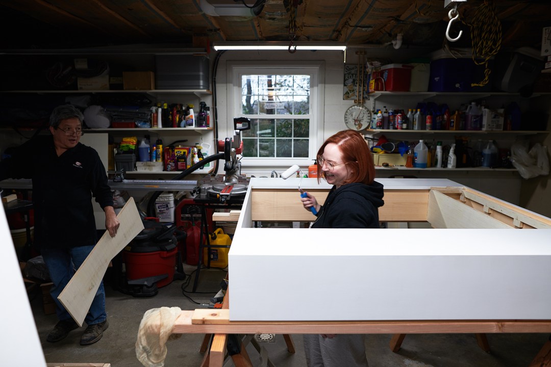 Emily Cosnotti and her father building a white fireplace surround in a workshop