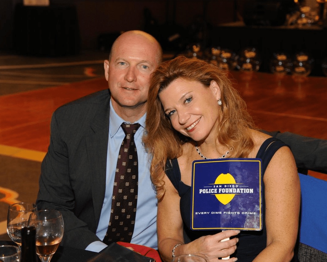 David Rex and Emily Rex seated together, Emily holding a San Diego Police Foundation program