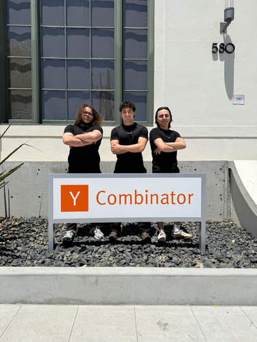 Emre Isik and his SpaceFlow co-founders standing behind a Y Combinator sign in San Francisco