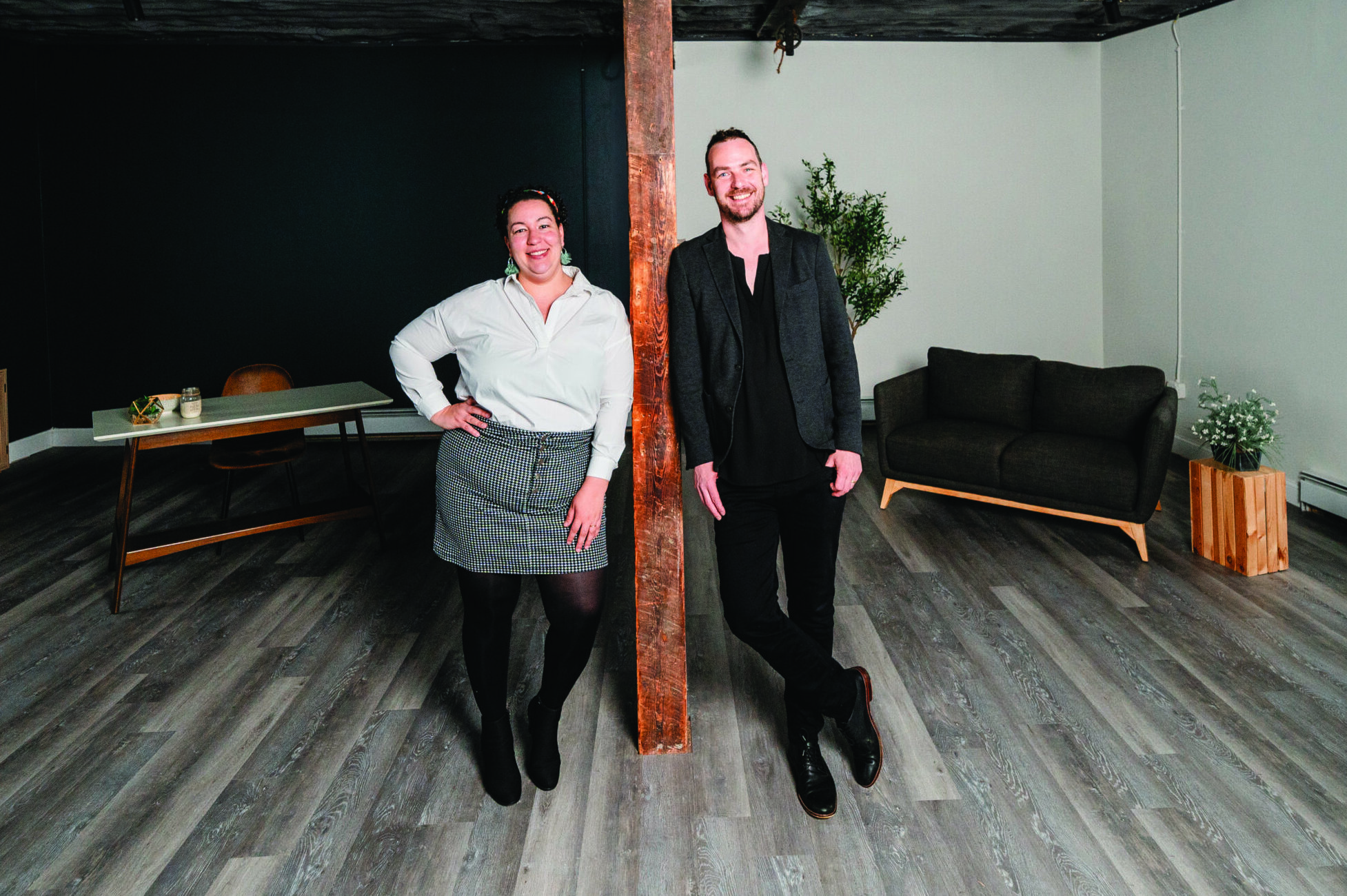 Dr. Tariana Little and Jonas Meyer standing on opposite sides of a timber post inside EmVision Studios