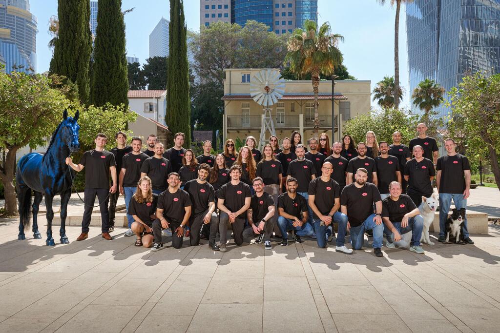 Encore AI team pictured outdoors beside a blue horse sculpture, with two dogs