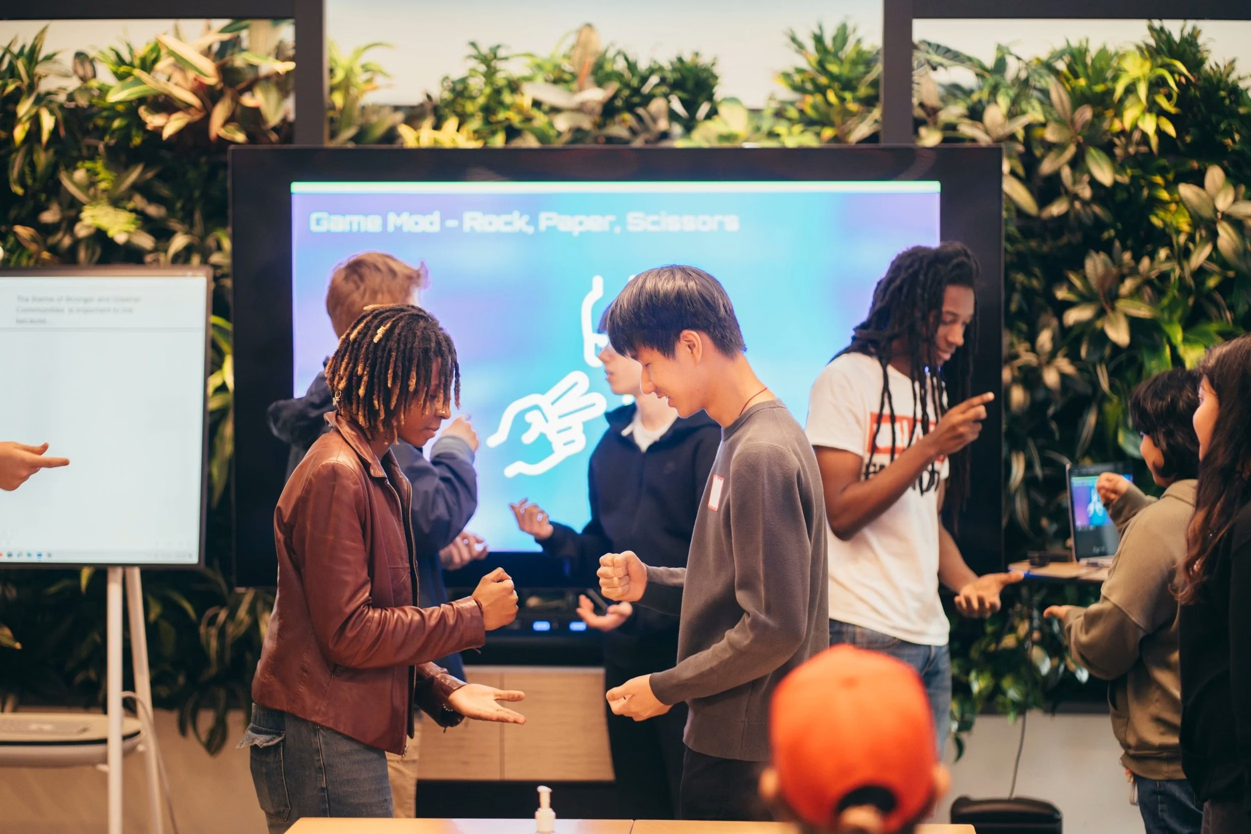 Young creators talking beside a game event display