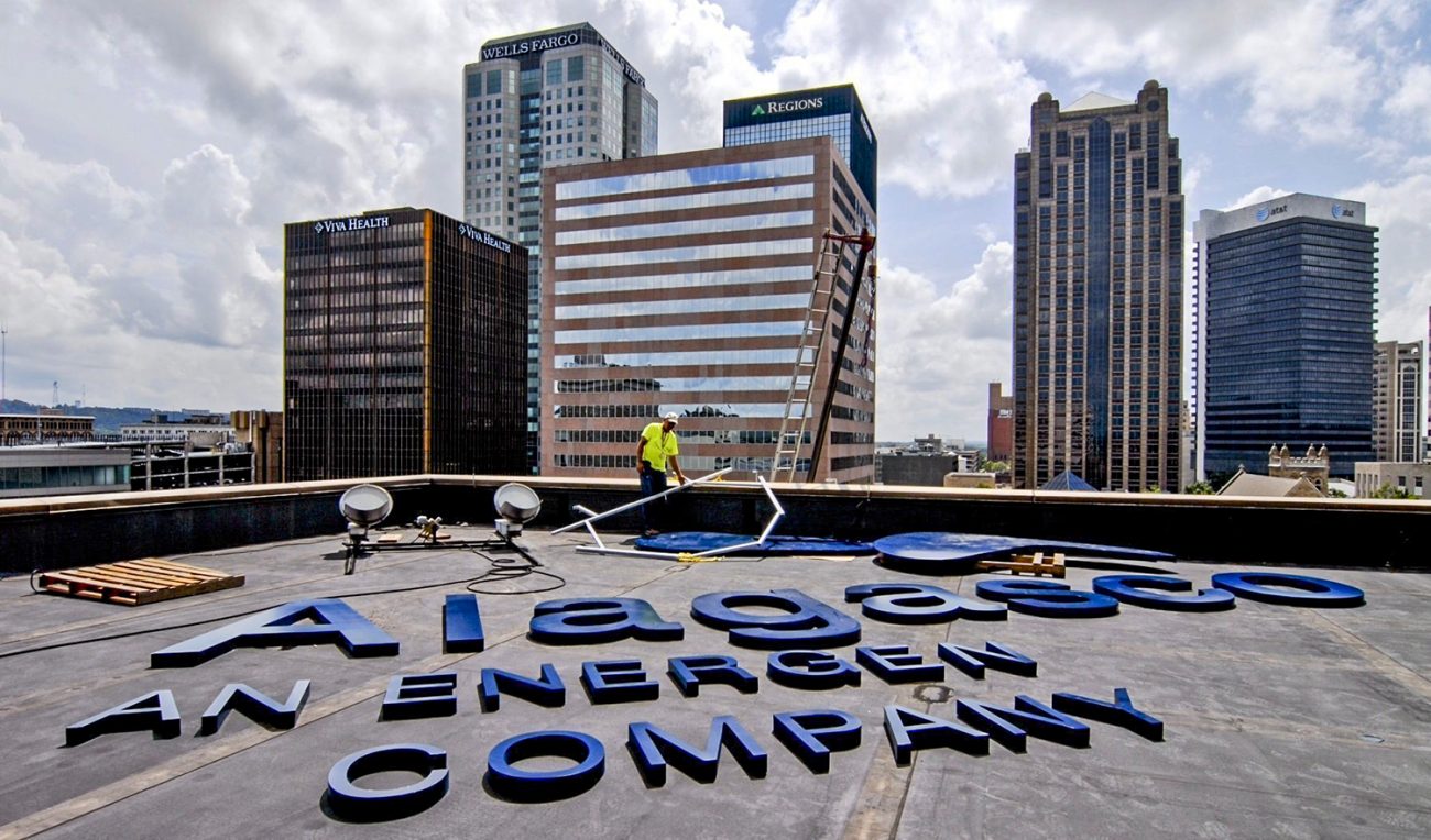 A worker removes the Alagasco sign from Energen’s Birmingham headquarters in March 2016.