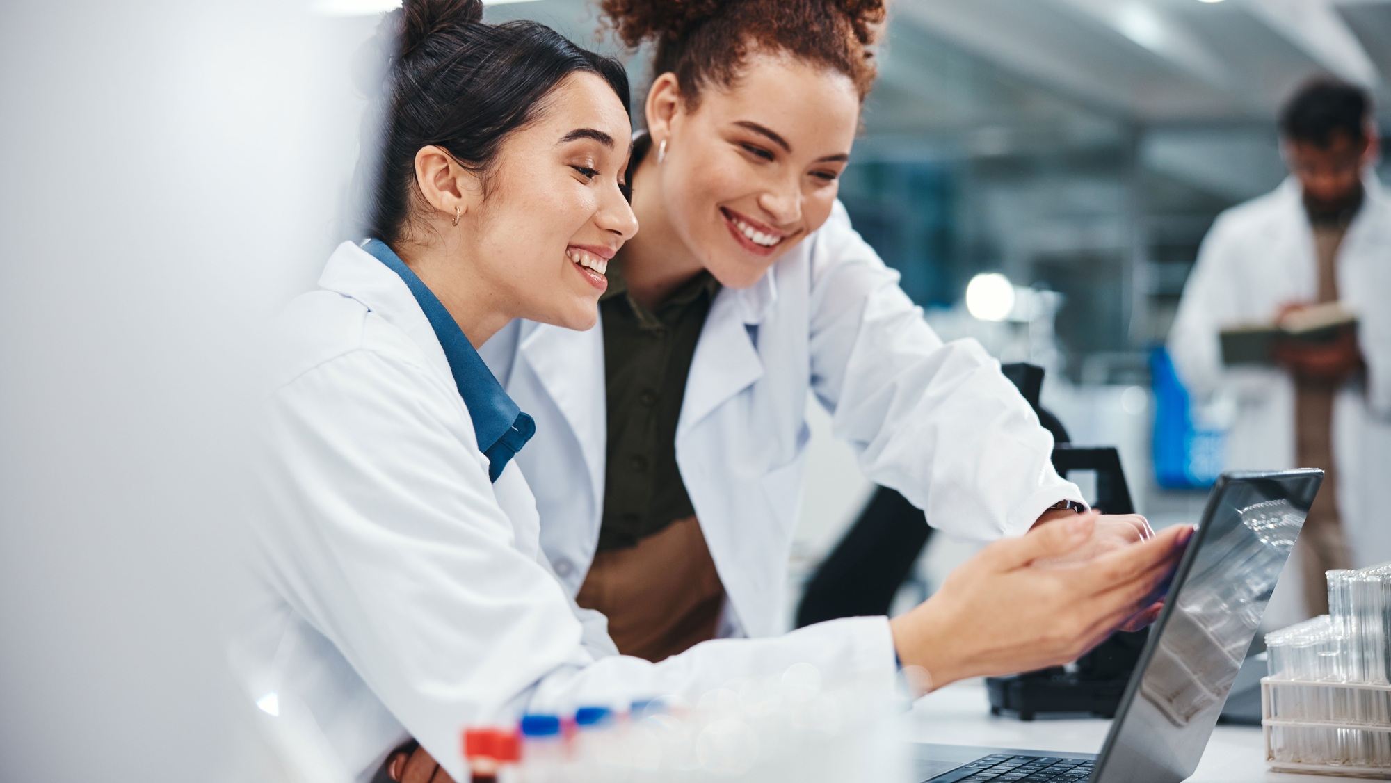 Two healthcare professionals looking at a tablet in a pharmacy setting