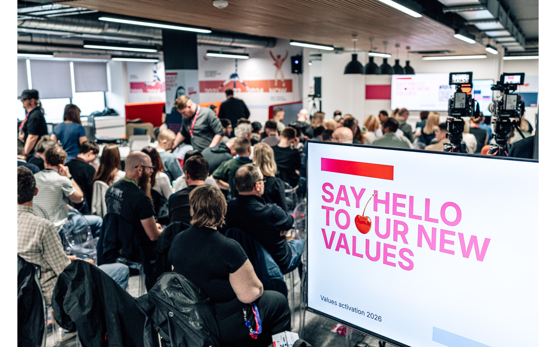 ENSEK employees attending the June 2026 values launch, with a presentation screen and cameras