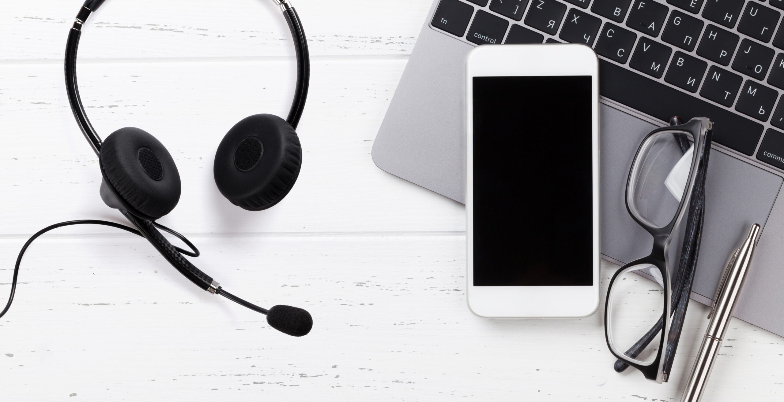 Headset, phone and laptop in Enservio’s website illustration