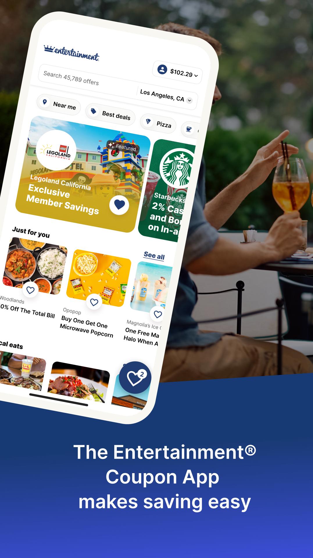 Entertainment’s promotional app image showing nearby offers on a phone beside restaurant diners