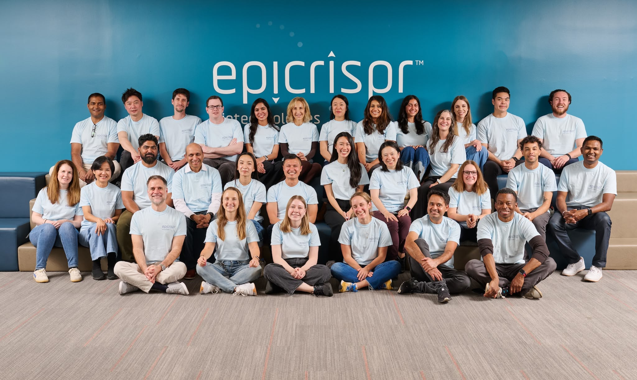 Epicrispr team gathered in front of the company's blue wall