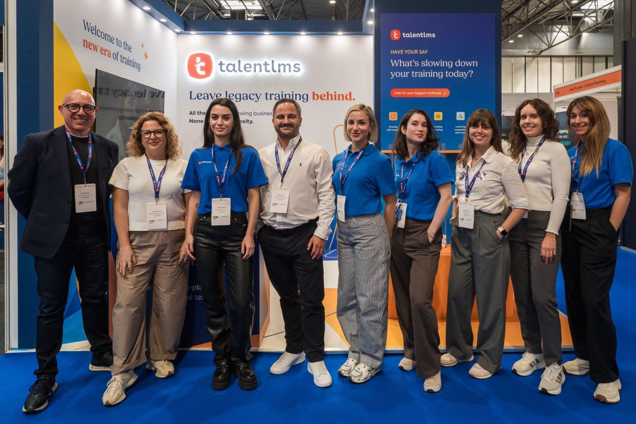 TalentLMS team standing at its World of Learning 2026 exhibition booth