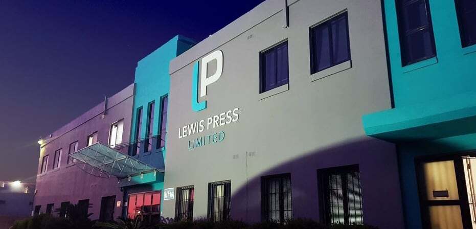 Lewis Press factory exterior illuminated at dusk
