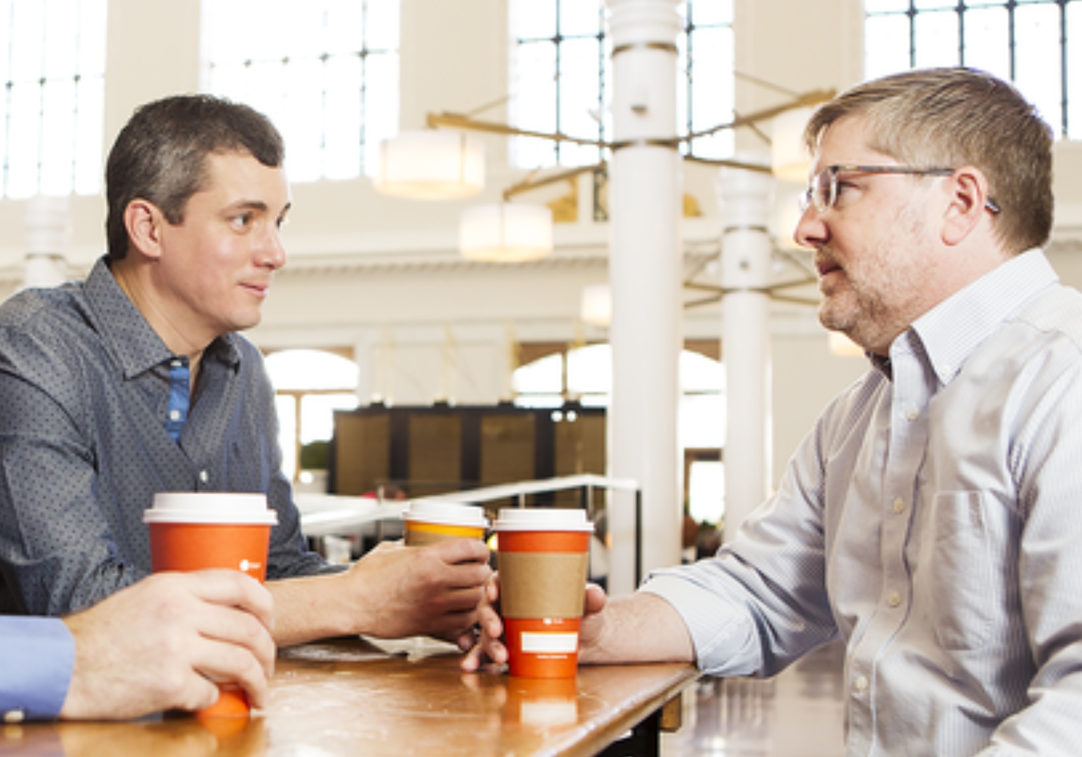 Two people in conversation over coffee in the photograph on Equus’s company page