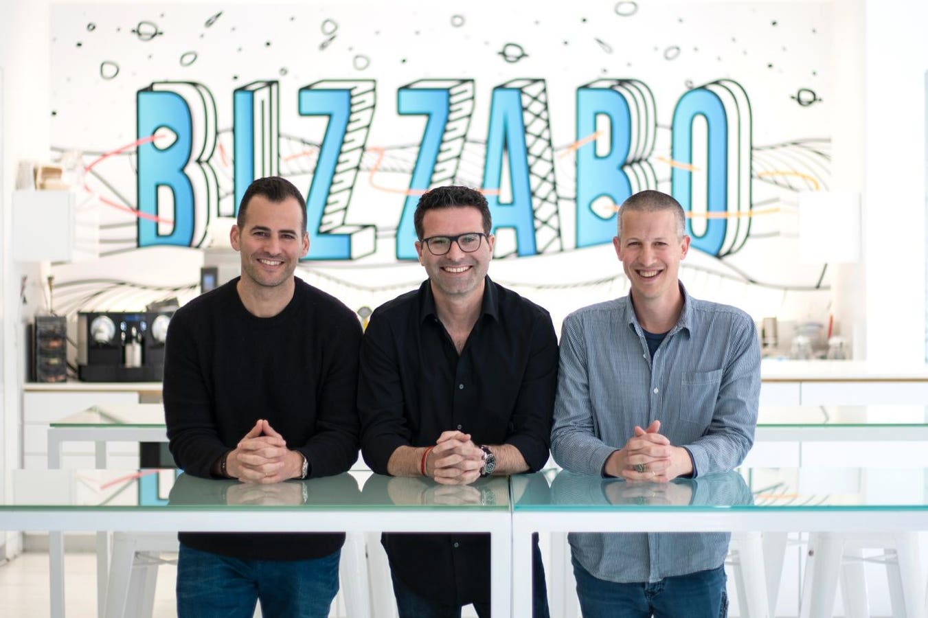 Bizzabo co-founders Alon Alroy, Eran Ben-Shushan, and Boaz Katz seated together in the company's office