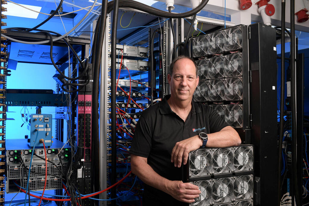 Erez Freibach standing among server racks and cooling equipment in a ZutaCore lab